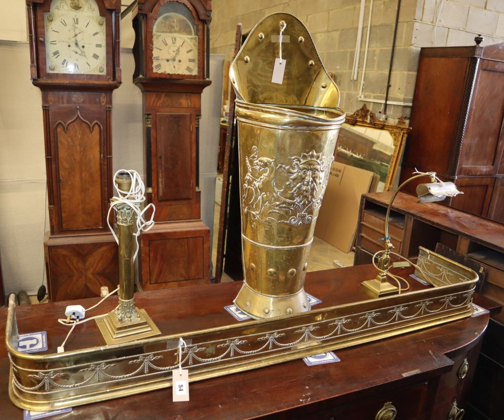 Four brass items, comprising a students lamp, a table lamp, a grape pannier stick stand and a fender, stick stand H.86cm